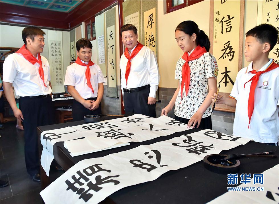 習(xí)近平觀看學(xué)生書寫的毛筆字。
